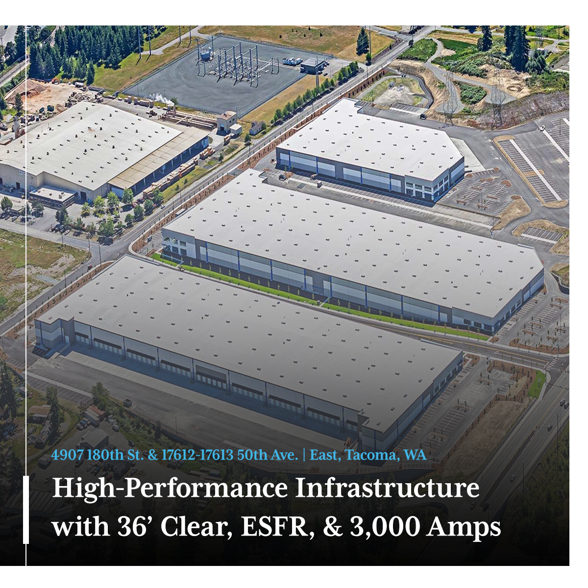 Exterior view of a modern commercial building with large windows, signage, and landscaping in front.