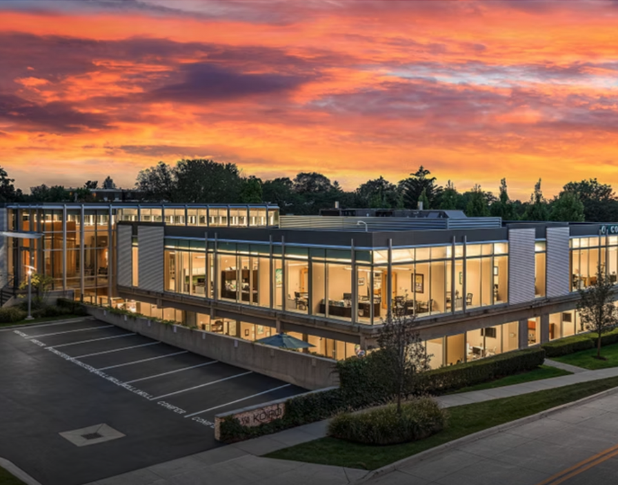 Exterior view of modern office building featuring reserved parking and curb appeal at sunset