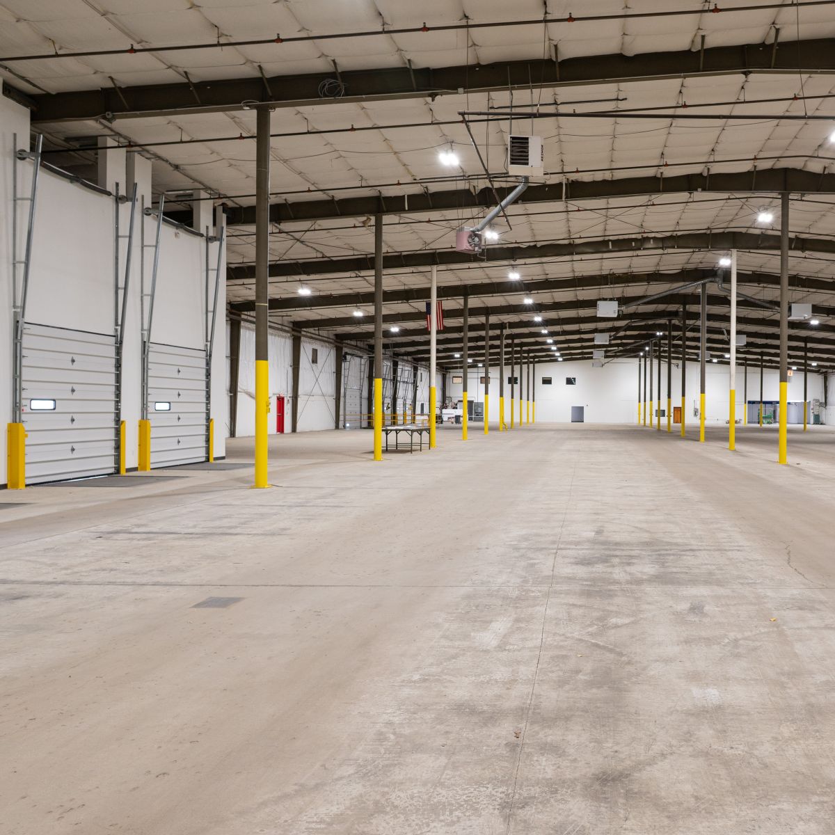 A spacious industrial loading area featuring high ceilings and minimal decor.