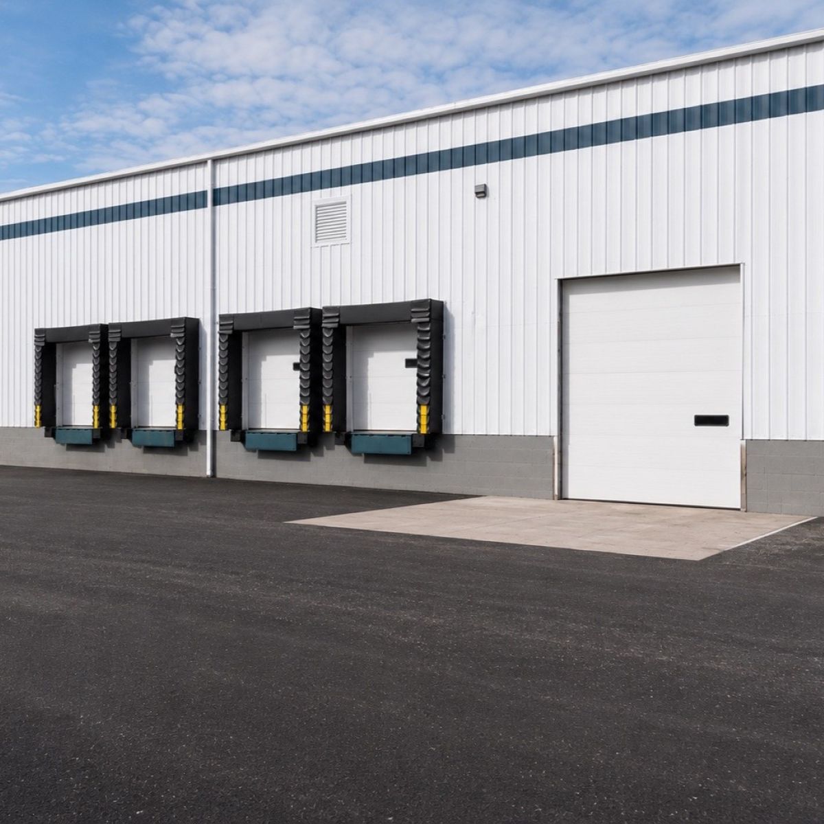 Exterior view of loading docks and an entrance door on a commercial warehouse building.