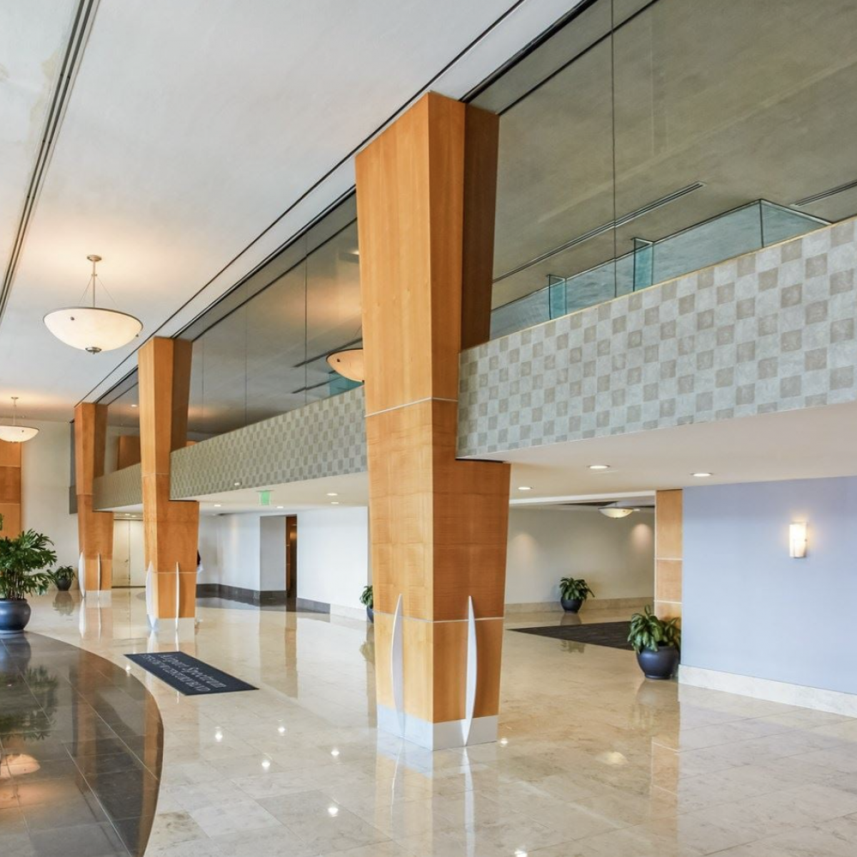 Spacious commercial building lobby with decorative pillars and plants